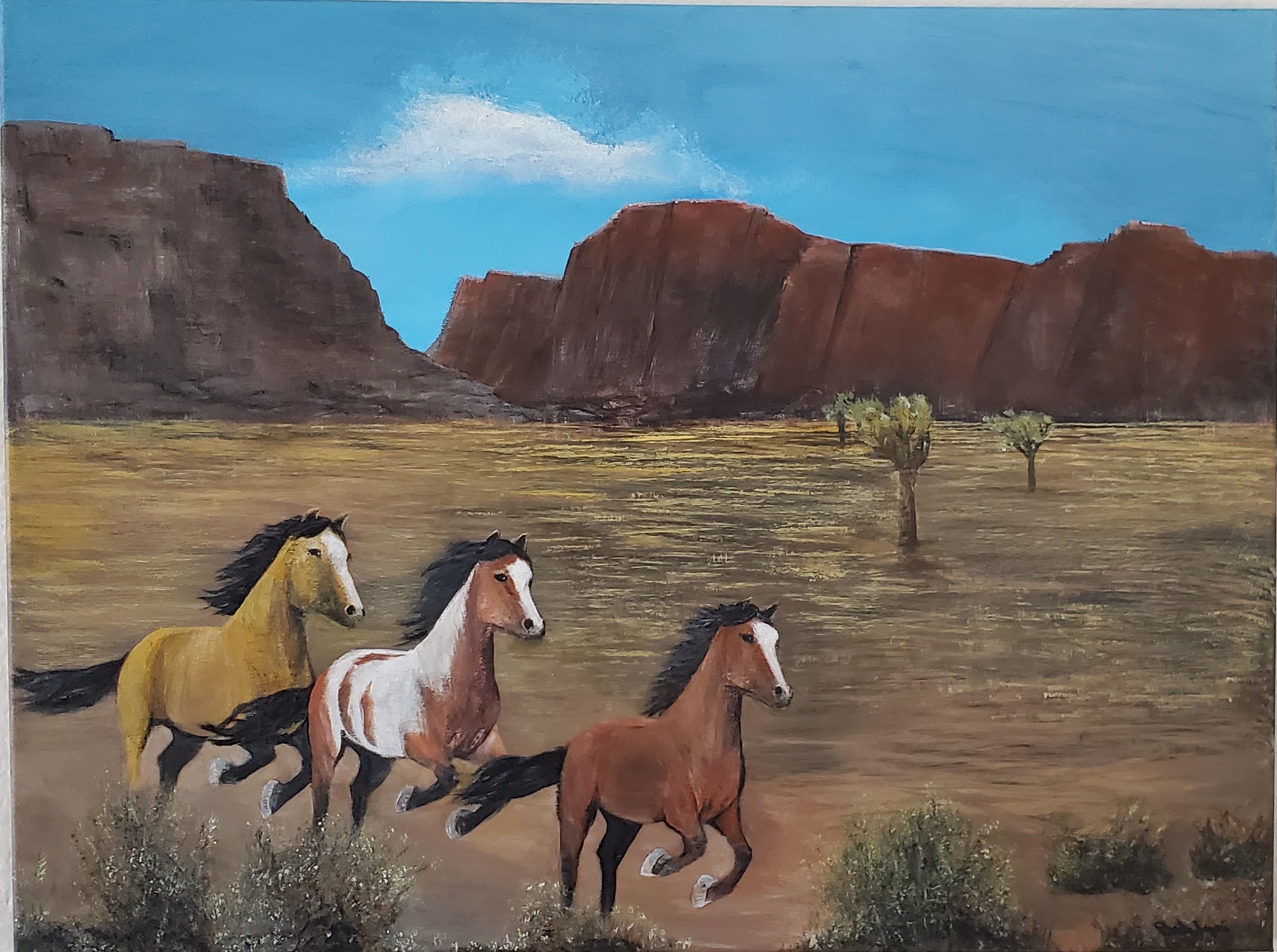 Acrylic painting of wild horses running through a red rock desert landscape
